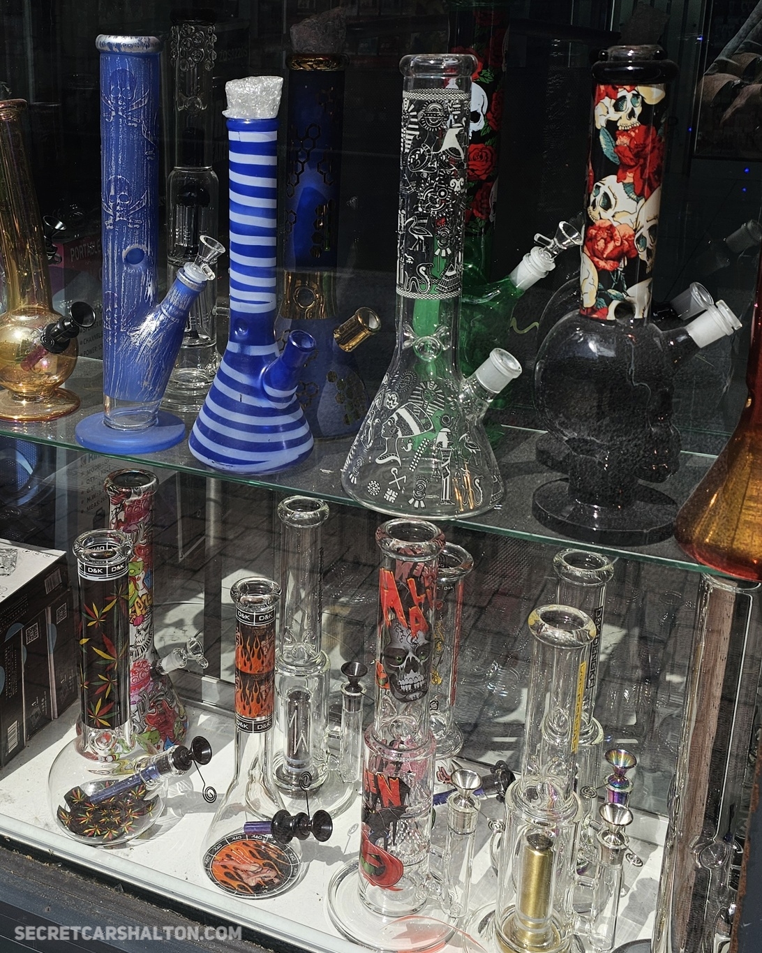 A shop window display of colourful glass bongs and smoking accessories on Carshalton High Street